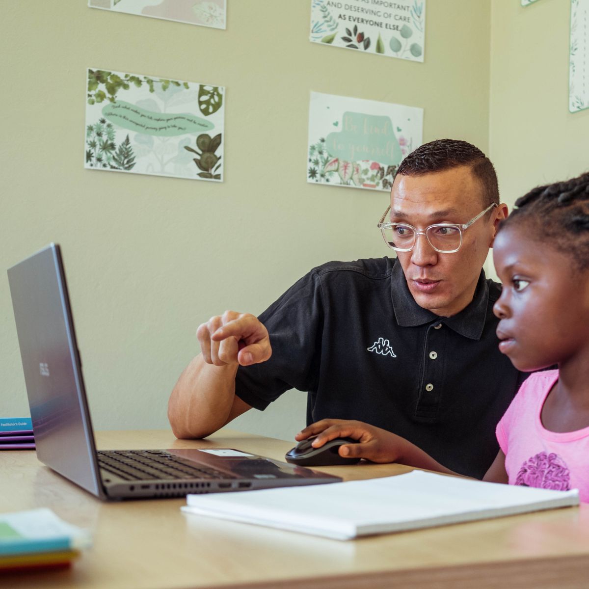 A child learning Afrikaans with a teacher using a laptop