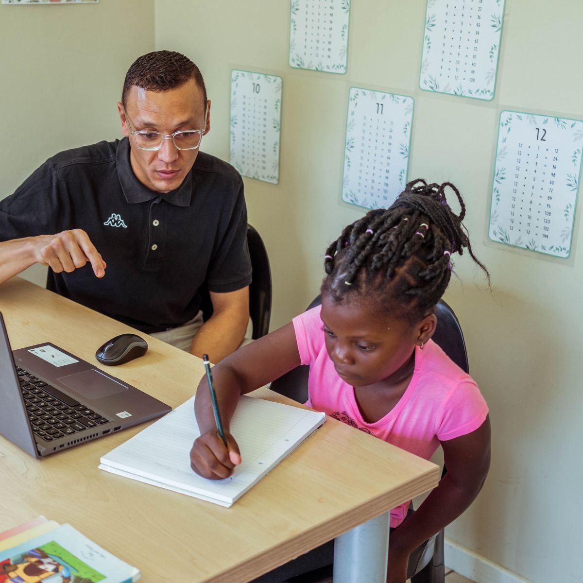 A teacher helping a learner create a study plan at a desk
