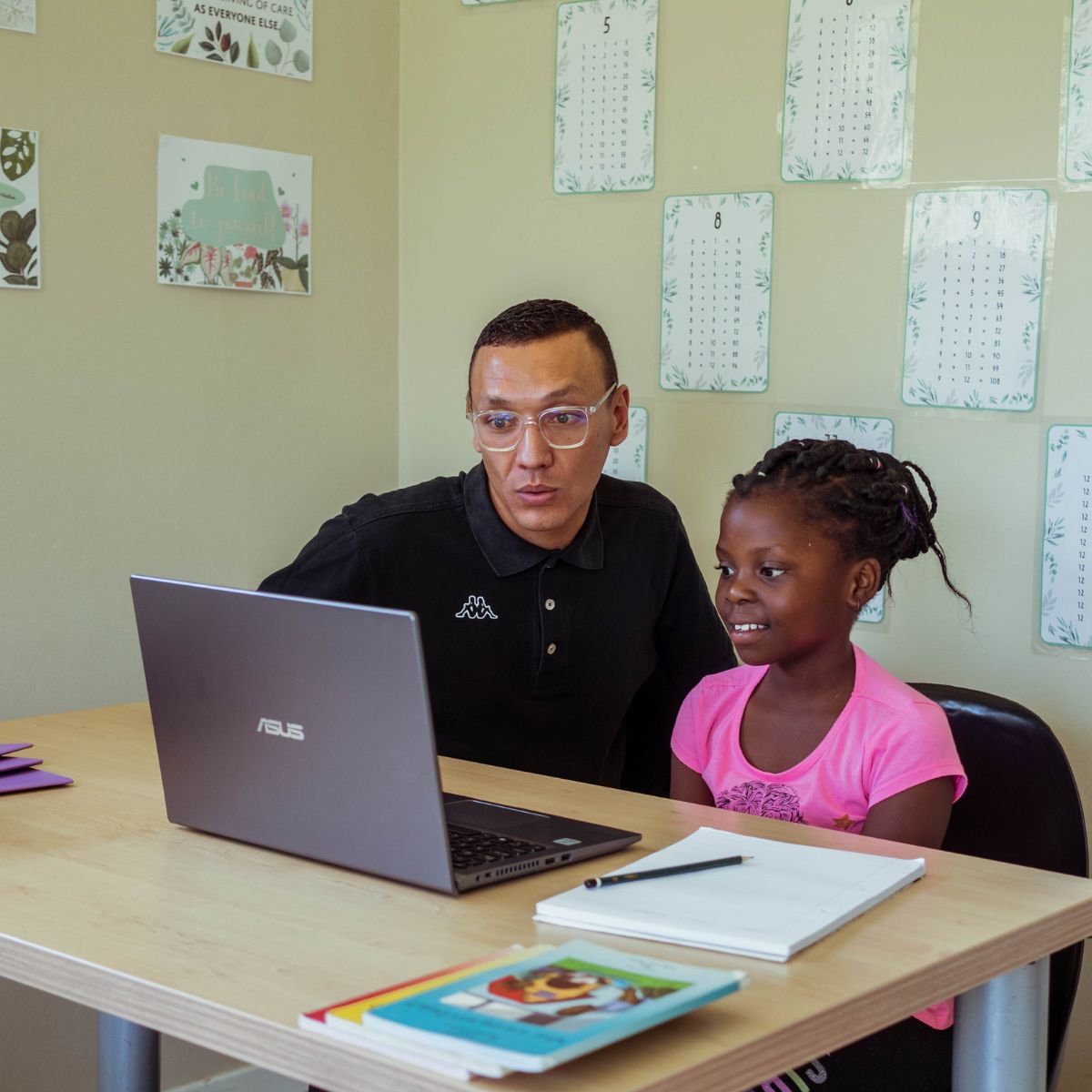 A teacher helping a student with their schoolwork one on one
