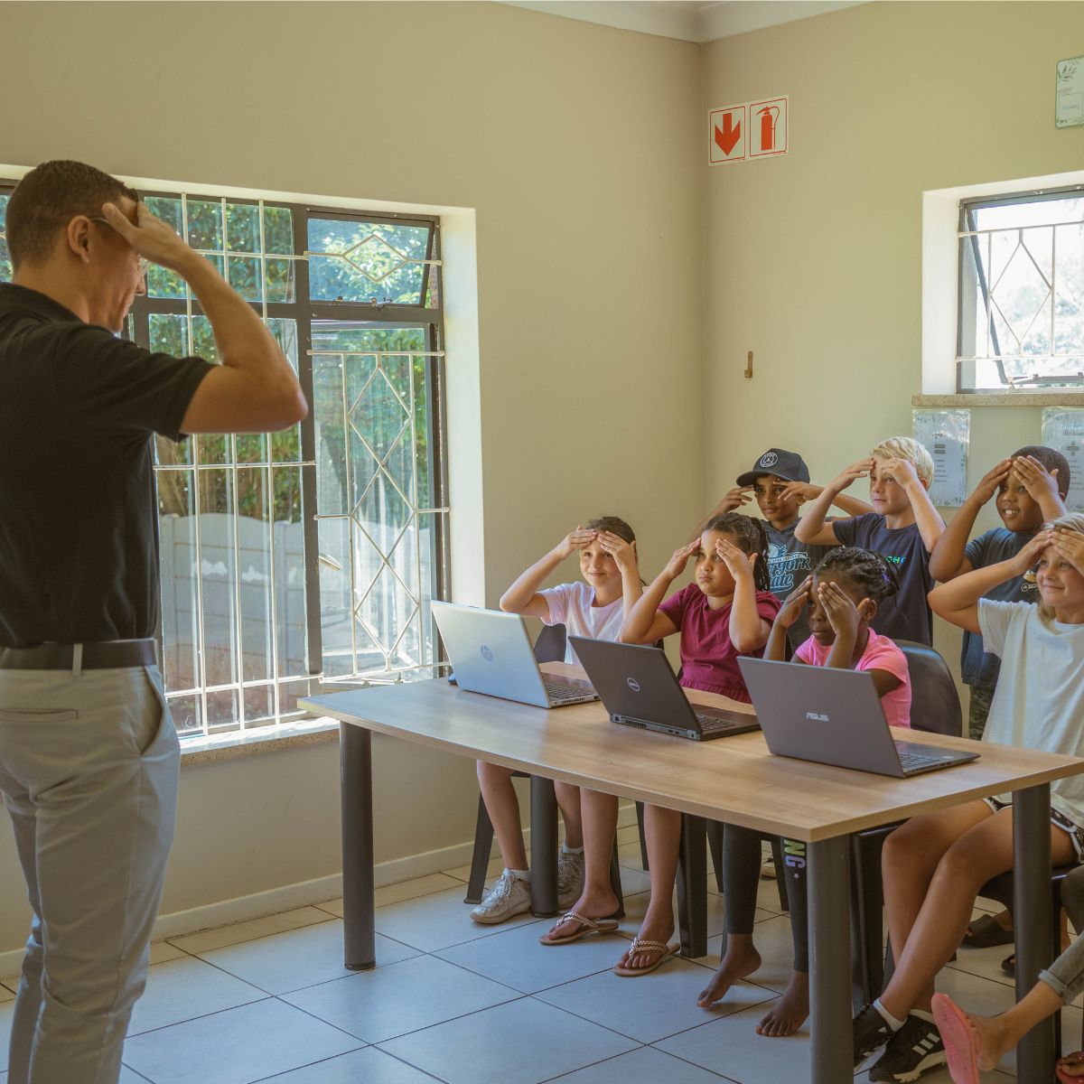 A teacher helping children who struggle with ADHD in a classroom