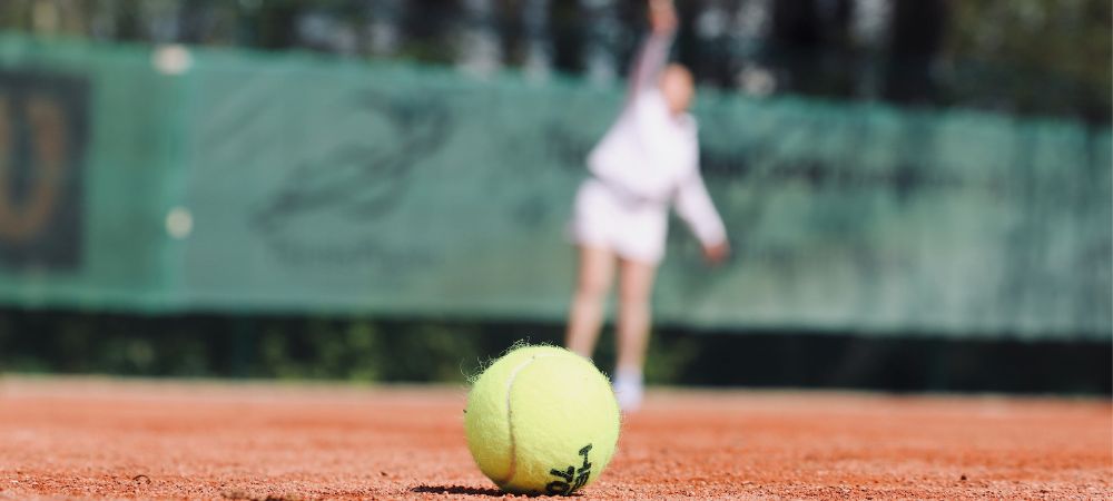 A close-up of a tennis ball representing the balance between schoolwork and sports