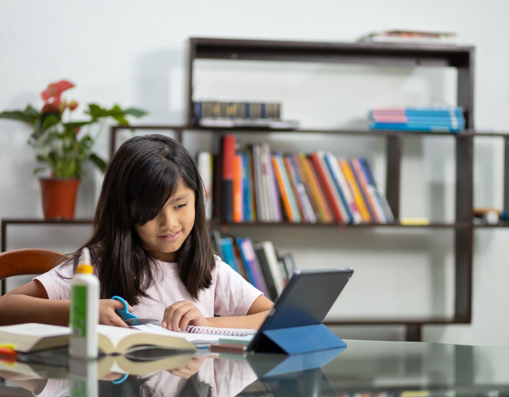 A child cutting paper during an after-school homework club activity